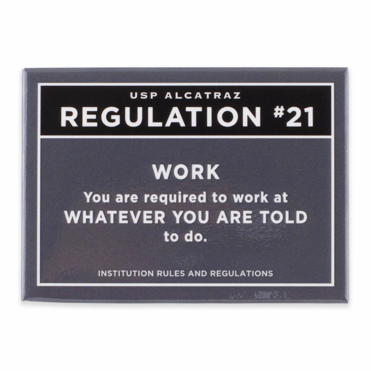 Rectangular dark grey magnet with text from U.S. Penitentiary Alcatraz Regulation 21 in white, with black accent: “You are required to work at whatever you are told to do.”