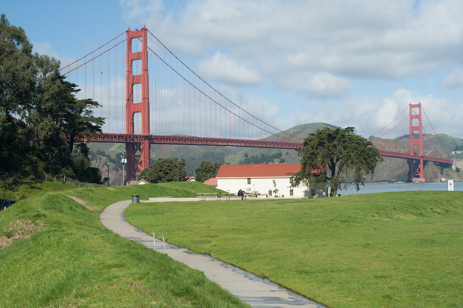 A view towards the Warming Hut Bookstore and Cafe on Crissy Field, with Golden Gate Bridge in the background.
