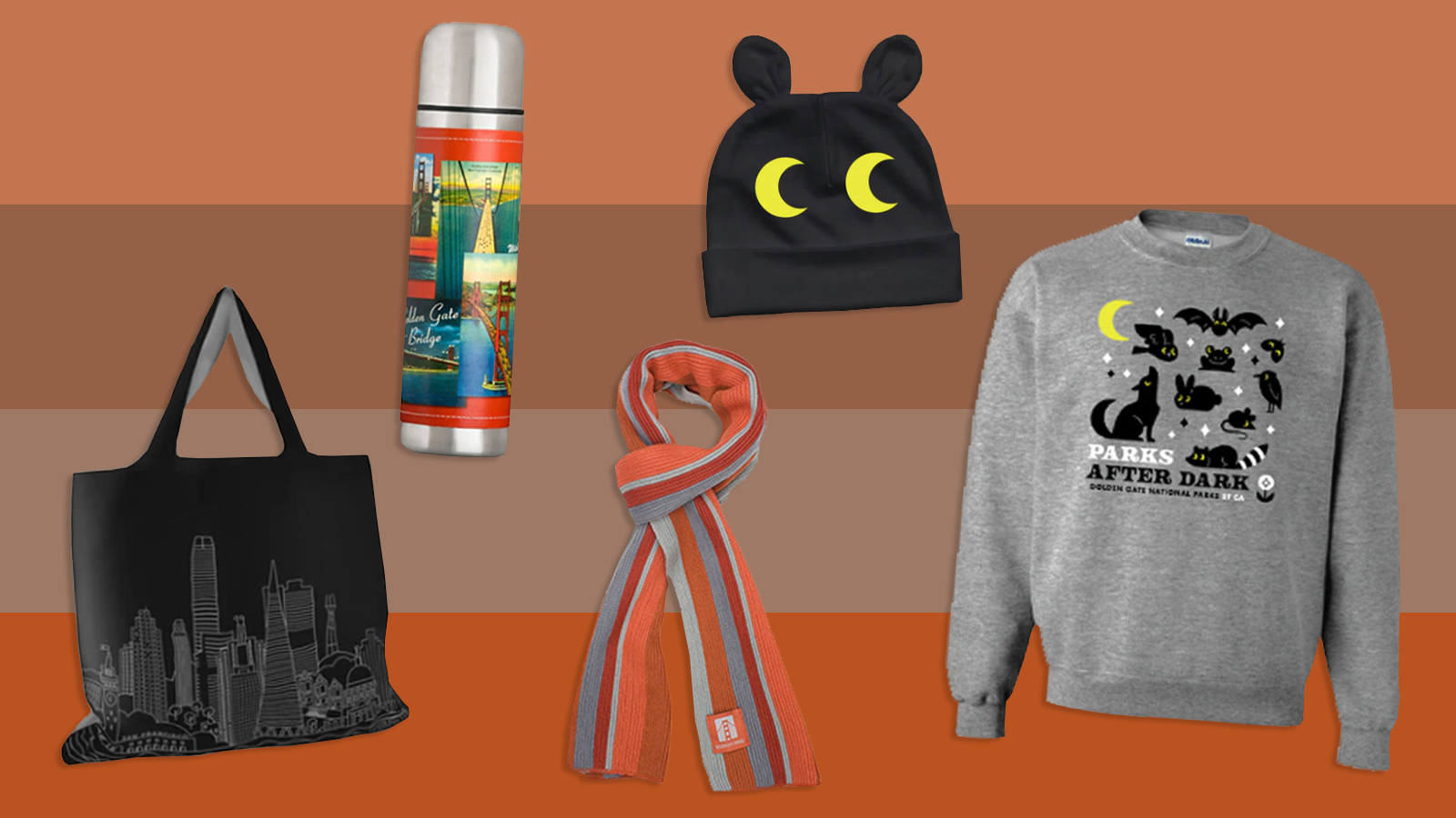 Cheerful fall products (animal beanie and sweatshirt, orange scarf, tote bag, etc.) on colorful orange colorblock background.