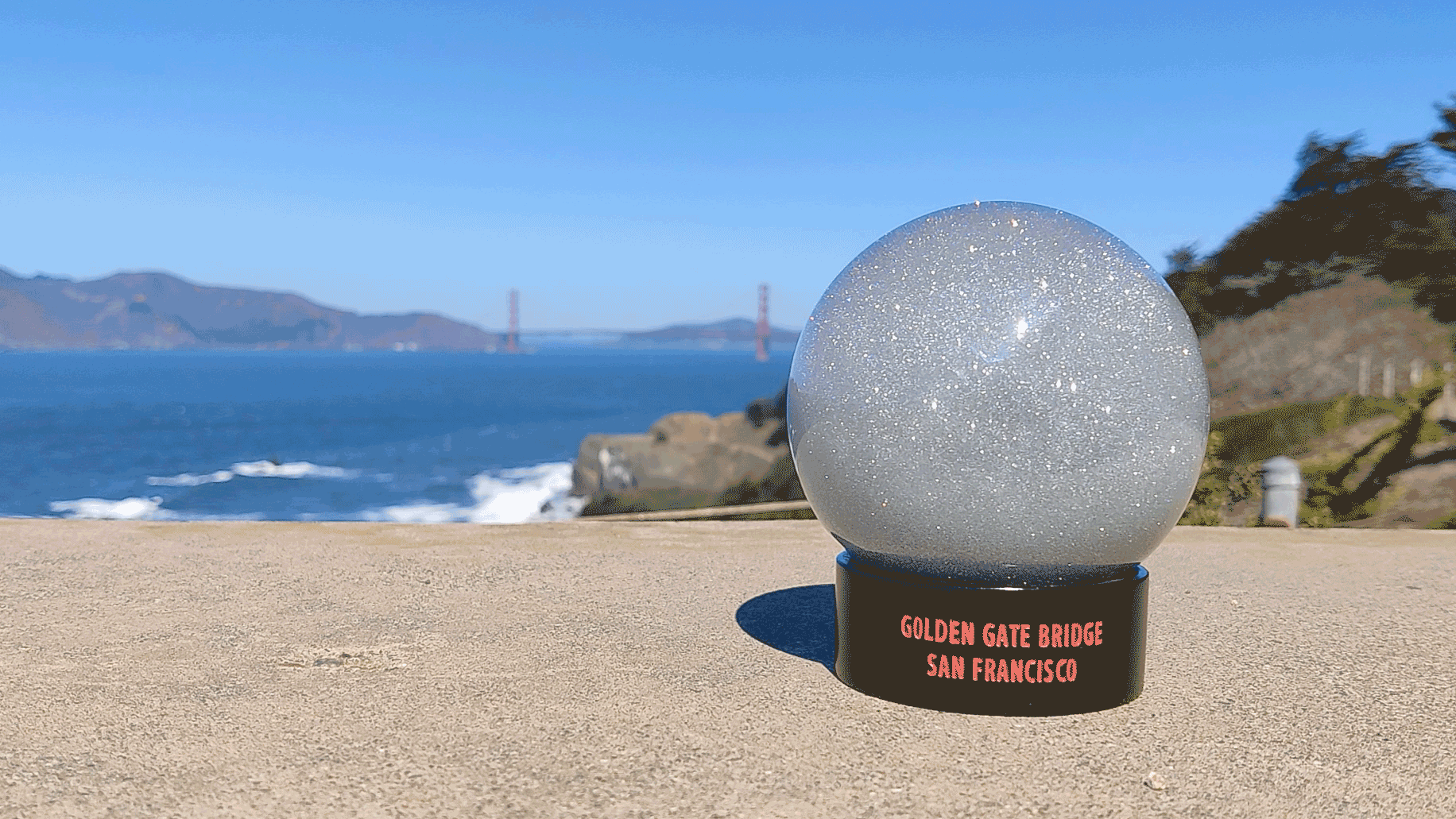Animated gif of Golden Gate Bridge fog globe, with view of Golden Gate Bridge and San Francisco Bay in background on a sunny day.