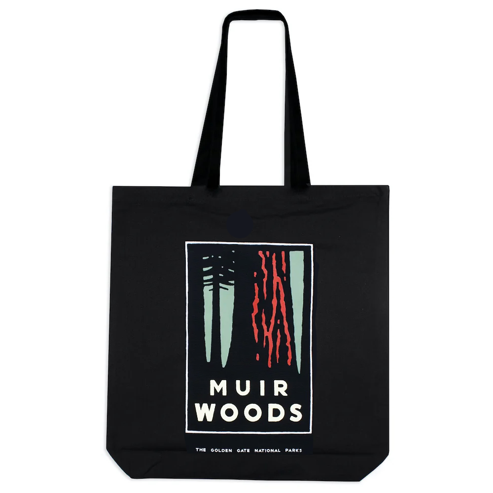 Black tote bag with colorful screen printed Muir Woods illustration with tree and words on front, art by Michael Schwab