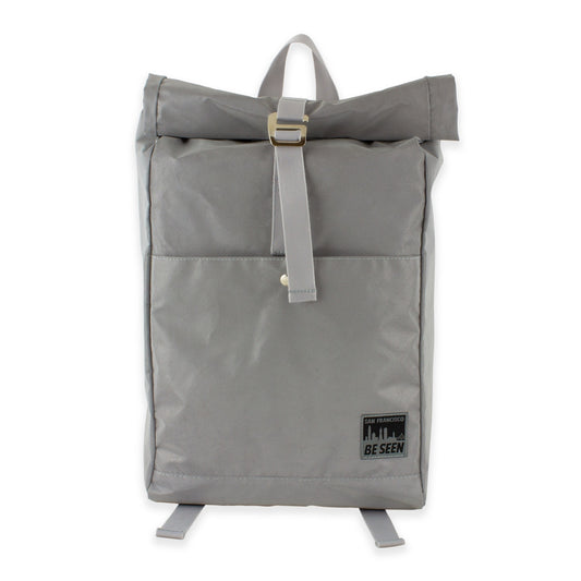 Reflective grey backpack with black and grey San Francisco Be Seen logo on front pocket.