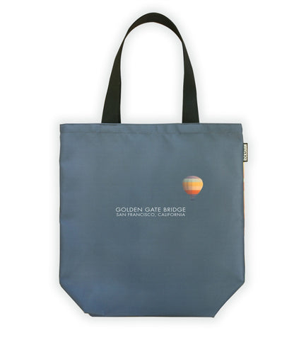 Grey tote bag with black handle, words "Golden Gate Bridge San Francisco, California" in white at center, with colorful illustration of hot air balloon.