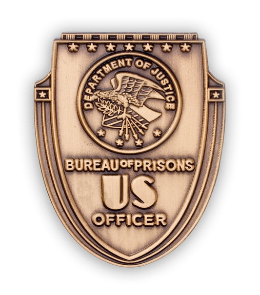 Replica Department of Justice Bureau of Prisons "US Officer" hat pin. Shape of shield with eagle DOJ logo at center.