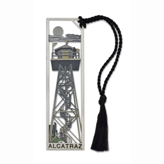 Rectangular bookmark with illustration of Alcatraz Island tower by moonlight in muted grey tones, printed on cutout metal. Black cord with tassel.