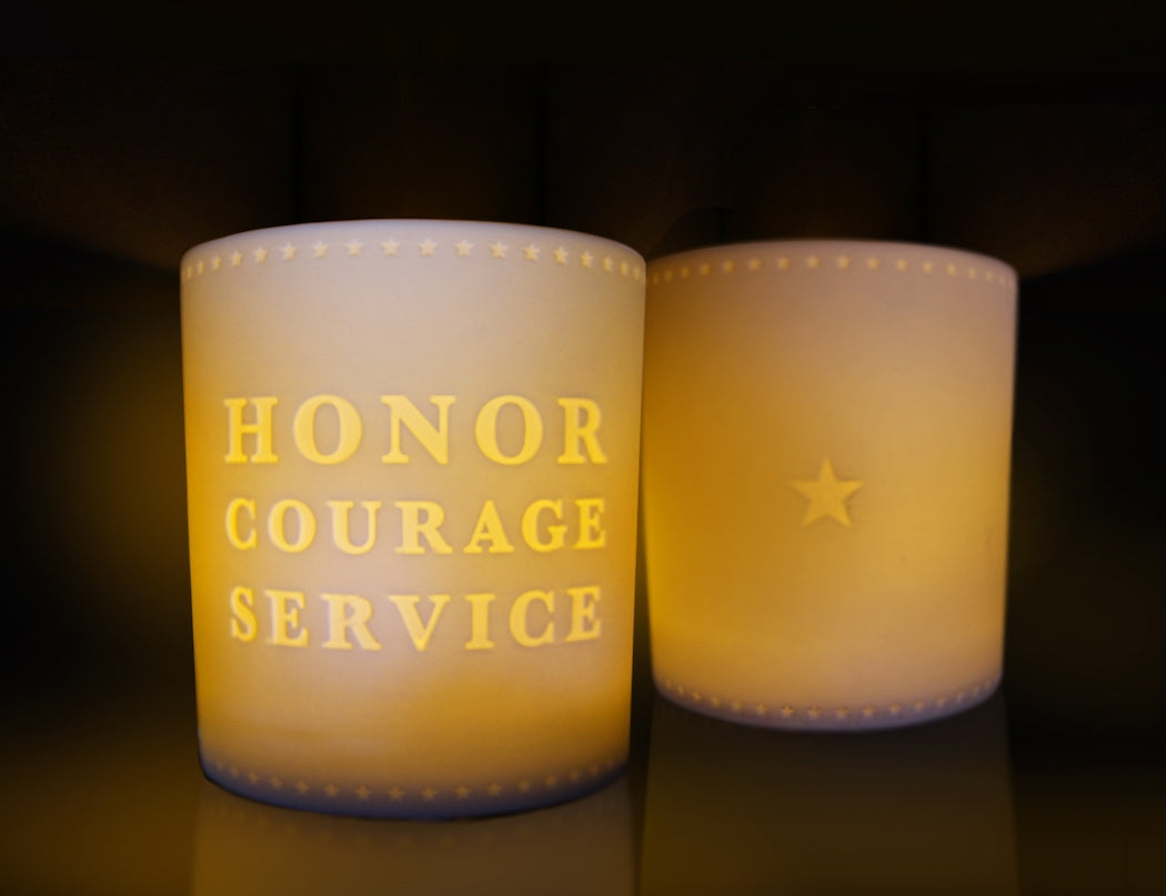 White votive tealight candle holder with words "Honor Courage Service" and border of stars along top and bottom.